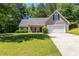 Charming home featuring a well-manicured lawn, a two-car garage, and updated siding at 90 Loudoun Dr, Covington, GA 30014