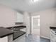 Modern kitchen with white cabinets, black countertop and views into another room at 90 Loudoun Dr, Covington, GA 30014