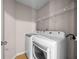 Laundry room equipped with modern washer and dryer units and wire shelving for storage at 90 Loudoun Dr, Covington, GA 30014
