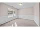 Inviting room features wainscoting, a large window, and soft carpeting at 90 Loudoun Dr, Covington, GA 30014