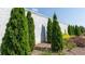 Landscaped area showcasing neatly trimmed evergreen trees and a white wall at 1814 Butterfly Way, Marietta, GA 30066