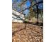 View of side yard with leaf covered ground and partially visible detached garage at 1997 Bethsaida Rd, Riverdale, GA 30296