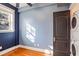 Bedroom with blue accent wall, hardwood floors, and natural light with a view of washer and dryer at 908 Juniper Ne St # 205, Atlanta, GA 30309