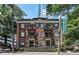 Multi-story brick building with charming balconies, flags, and well-maintained landscaping at 908 Juniper Ne St # 205, Atlanta, GA 30309