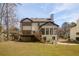 View of a two-story home featuring a wooden deck, a fenced yard, and mature trees at 1420 Midland Way, Lawrenceville, GA 30043