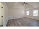 Spacious main bedroom featuring a tray ceiling, ceiling fan, two windows and wood-look flooring at 1420 Midland Way, Lawrenceville, GA 30043