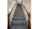 Traditional staircase featuring carpeted steps, white risers, and stained wood handrails and banisters at 1420 Midland Way, Lawrenceville, GA 30043