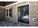 Exterior features a stone facade, black double doors, and a flagstone patio at 1150 Sweet Mia Ln, Powder Springs, GA 30127