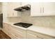 White kitchen cabinets and gas cooktop with herringbone backsplash at 1150 Sweet Mia Ln, Powder Springs, GA 30127