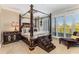 Opulent bedroom featuring a four-poster bed, elegant furniture, and large windows with plantation shutters at 750 Park Ne Ave # 8E, Atlanta, GA 30326