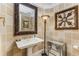 Elegant powder room with pedestal sink, ornate mirror, decorative wall art, and stylish lighting at 750 Park Ne Ave # 8E, Atlanta, GA 30326
