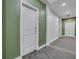 Residential hallway with green walls, carpet flooring, and apartment doors at 565 Peachtree Ne St # 1509, Atlanta, GA 30308