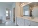 Bathroom with double sinks, large mirror, tiled floor, and modern fixtures at 173 Haverling Pass, Hampton, GA 30228