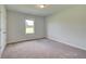 Bedroom with neutral carpet, natural light from the window, and crisp white walls at 173 Haverling Pass, Hampton, GA 30228