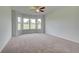 Sunlit primary bedroom with a ceiling fan and multiple windows offering scenic views at 173 Haverling Pass, Hampton, GA 30228