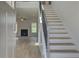 Bright foyer with staircase, and open view of the living area featuring a fireplace and wood flooring at 173 Haverling Pass, Hampton, GA 30228