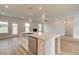 Modern kitchen with stainless steel appliances, island sink and light hardwood floors at 173 Haverling Pass, Hampton, GA 30228