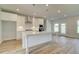 Modern kitchen with white cabinets, island with seating, stainless steel appliances and wood floors at 173 Haverling Pass, Hampton, GA 30228