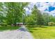 Gravel driveway leading to a charming log cabin in a wooded area at 58 Wesley Chapel Ln, Villa Rica, GA 30180