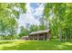 Log cabin home surrounded by lush greenery and large trees at 58 Wesley Chapel Ln, Villa Rica, GA 30180