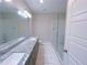 Bathroom featuring double sinks with granite counters, a glass-enclosed shower and modern tile at 2005 Ocean Nw Dr, Atlanta, GA 30318
