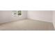 A clean, carpeted bedroom with a large window offering natural light and an exterior view at 491 Reflection Dr # 33, Stockbridge, GA 30281