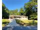 Ranch home with a long driveway, lush lawn, and mature trees surrounding the property at 3263 Dodson Dr, Atlanta, GA 30344