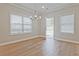 Open dining room with natural light from two windows and elegant chandelier at 913 Agate Ln, Lawrenceville, GA 30043