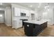 Modern kitchen with black island, quartz countertops, stainless steel appliances, and stylish pendant lighting at 913 Agate Ln, Lawrenceville, GA 30043