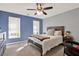 Comfortable bedroom featuring blue accent wall, ceiling fan, and two windows at 4511 Balmoral Nw Rd, Kennesaw, GA 30144