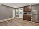 Basement kitchenette features brown cabinets, a stainless steel fridge and microwave with laminate floors at 4511 Balmoral Nw Rd, Kennesaw, GA 30144