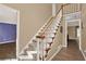 Carpeted staircase with wooden railings and a view into another room, adding to the home's charm at 4511 Balmoral Nw Rd, Kennesaw, GA 30144