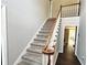 Carpeted staircase with a classic wooden handrail leading to the second floor of the home at 4511 Balmoral Nw Rd, Kennesaw, GA 30144