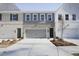 New townhome exteriors with brick and siding, featuring garages, landscaped front yards, and modern architectural design at 909 Agate Ln, Lawrenceville, GA 30043