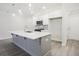 Bright kitchen features white cabinetry, gray backsplash, stainless steel appliances, and a gray kitchen island at 909 Agate Ln, Lawrenceville, GA 30043