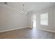 Bright living room featuring hardwood floors, modern chandelier, and neutral paint, creating a cozy atmosphere at 909 Agate Ln, Lawrenceville, GA 30043