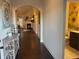 Hallway featuring hardwood floors, neutral walls, arched doorways, and a glimpse of the living room at 1124 Kingston Hill Dr, Loganville, GA 30052