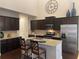 Modern kitchen with stainless steel appliances, granite countertops, and dark wood cabinetry at 1124 Kingston Hill Dr, Loganville, GA 30052