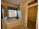 Bright bathroom featuring a soaking tub and a doorway to the walk-in closet at 1124 Kingston Hill Dr, Loganville, GA 30052