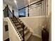 Carpeted staircase with dark wood banister and wrought iron balusters at 1124 Kingston Hill Dr, Loganville, GA 30052