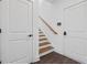Entry way featuring a staircase with wooden steps and access to two doorways in modern designed home at 161 Brush Creek Ct, Stockbridge, GA 30281