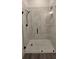 View of a frameless glass shower with marble-patterned tile and black hardware at 161 Brush Creek Ct, Stockbridge, GA 30281