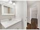 Bathroom features a large, lighted mirror over a white sink with matching cabinets and hardwood floors at 508 Sutters Mill Rd, Stone Mountain, GA 30087