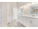 Bright bathroom showcasing double vanity with white countertop and modern fixtures, plus wood-like tile flooring at 508 Sutters Mill Rd, Stone Mountain, GA 30087