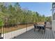 Outdoor deck area with dining furniture and a view of the wooded backyard at 165 Brush Creek Ct, Hampton, GA 30281