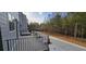 View of the outdoor balcony overlooking the green backyard and a concrete driveway at 165 Brush Creek Ct, Hampton, GA 30281