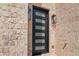 Stylish front door set in a light brick facade with modern lighting fixtures at 165 Brush Creek Ct, Hampton, GA 30281