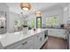 A spacious white kitchen featuring a large island with bar stools and stainless steel appliances at 165 Brush Creek Ct, Hampton, GA 30281
