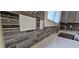 Close up of the gray mosaic backsplash, stainless faucet, and quartz countertops in the kitchen at 165 Brush Creek Ct, Hampton, GA 30281