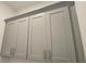 Close-up view of new gray-tone laundry room cabinets with brushed steel hardware at 165 Brush Creek Ct, Hampton, GA 30281